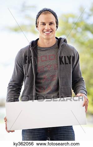 Portrait of a man holding a blank placard View Large Photo Image Stock Photograph - Portrait of a man holding a blank placard. Fotosearch