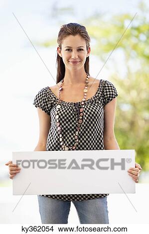 Portrait of a woman holding a blank placard View Large Photo Image Picture - Portrait of a woman holding a blank placard. Fotosearch