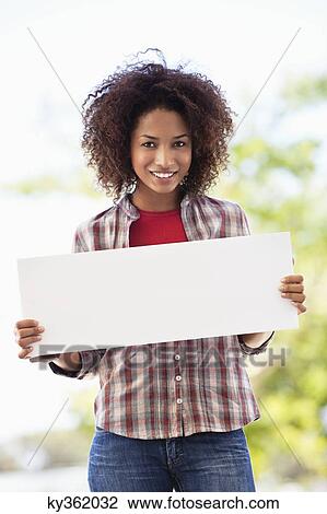 Portrait of a woman holding a blank placard View Large Photo Image Stock Image - Portrait of a woman holding a blank placard. Fotosearch