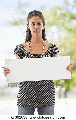 Stock Photo - Portrait of a woman holding a blank placard. Fotosearch