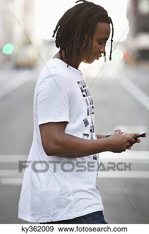 Side profile of a man text messaging on a mobile phone View Large Photo Image Stock Photo - Side profile of a man text messaging on a mobile phone. Fotosearch