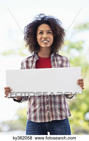 Woman holding a blank placard View Large Photo Image Stock Photo - Woman holding a blank placard. Fotosearch