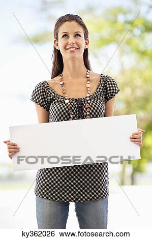 Woman holding a blank placard View Large Photo Image Stock Photograph - Woman holding a blank placard. Fotosearch