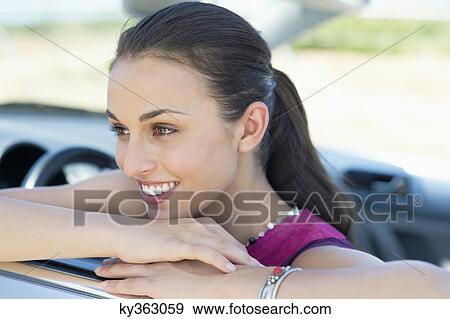 Beautiful young woman leaning on car window View Large Photo Image Stock Photo - Beautiful young woman leaning on car window. Fotosearch
