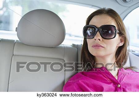 Beautiful young woman sitting in car View Large Photo Image Picture - Beautiful young woman sitting in car. Fotosearch