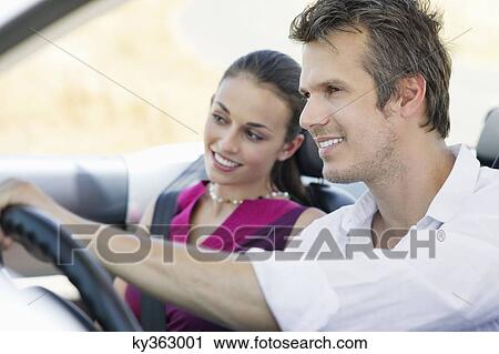 Couple driving a convertible car View Large Photo Image Stock Image - Couple driving a convertible car. Fotosearch