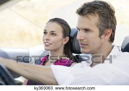 Couple driving a convertible car View Large Photo Image Stock Image - Couple driving a convertible car. Fotosearch