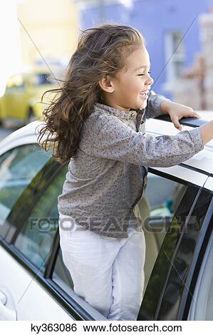 Stock Photograph - Cute little girl looking out of the car window. Fotosearch