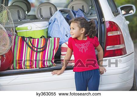 Stock Photography - Cute little girl standing by the car. Fotosearch