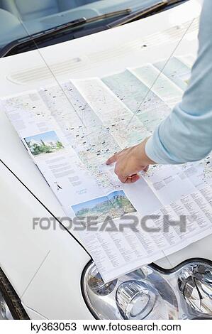 Man looking at a map on a car View Large Photo Image Stock Image - Man looking at a map on a car. Fotosearch