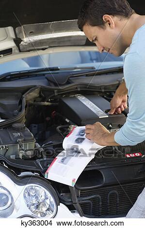 Mid adult man looking at broken car engine View Large Photo Image Picture - Mid adult man looking at broken car engine. Fotosearch