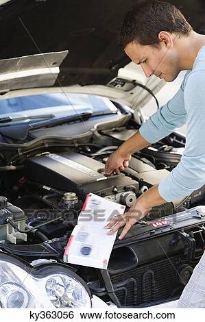 Mid adult man looking at broken car engine View Large Photo Image Stock Photograph - Mid adult man looking at broken car engine. Fotosearch