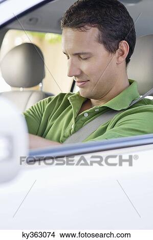Picture - Mid adult man sleeping while driving a car. Fotosearch