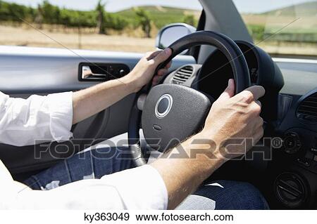 Mid adult man's hand holding a steering wheel of convertible car View Large Photo Image Stock Photo - Mid adult man's hand holding a steering wheel of convertible car. Fotosearch