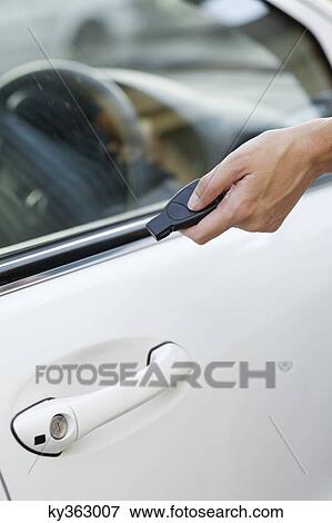 Stock Photo - Person's hand unlocking the car with remote control. Fotosearch