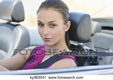 Portrait of a beautiful young woman driving a convertible car View Large Photo Image Stock Image - Portrait of a beautiful young woman driving a convertible car. Fotosearch