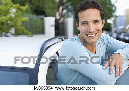 Picture - Portrait of a mid adult man leaning at open car door. Fotosearch