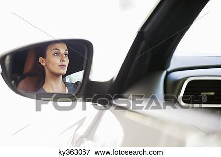 Reflection of a young woman on car's side glass while taking a test drive View Large Photo Image Stock Photo - Reflection of a young woman on car's side glass while taking a test drive. Fotosearch