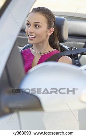 Young woman driving a convertible car View Large Photo Image Stock Image - Young woman driving a convertible car. Fotosearch