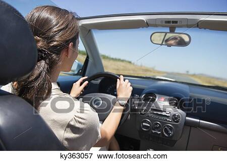 Young woman driving a convertible car View Large Photo Image Stock Photo - Young woman driving a convertible car. Fotosearch