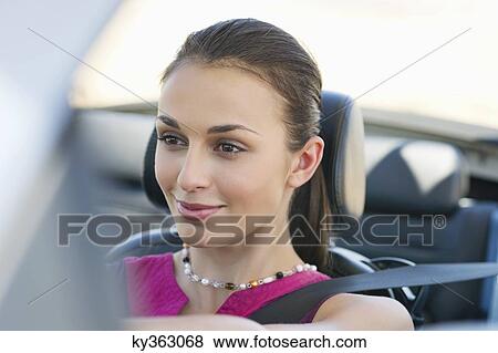 Young woman driving a convertible car View Large Photo Image Stock Photo - Young woman driving a convertible car. Fotosearch