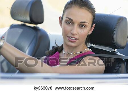 Young woman driving a convertible car View Large Photo Image Stock Photo - Young woman driving a convertible car. Fotosearch