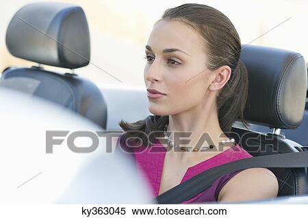 Young woman driving a convertible car View Large Photo Image Stock Photography - Young woman driving a convertible car. Fotosearch
