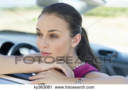 Young woman leaning on car window View Large Photo Image Stock Image - Young woman leaning on car window. Fotosearch