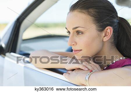 Young woman looking out of car window View Large Photo Image Stock Photograph - Young woman looking out of car window. Fotosearch