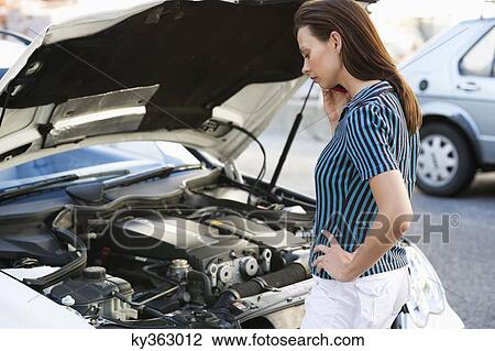 Young woman talking over phone and standing by the broken car View Large Photo Image Stock Image - Young woman talking over phone and standing by the broken car. Fotosearch