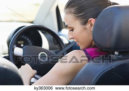 Young woman wearing a seat belt View Large Photo Image Stock Photograph - Young woman wearing a seat belt. Fotosearch