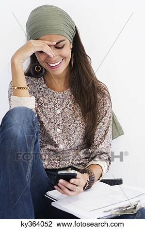 Beautiful woman using a mobile phone against white background View Large Photo Image Stock Image - Beautiful woman using a mobile phone against white background. Fotosearch