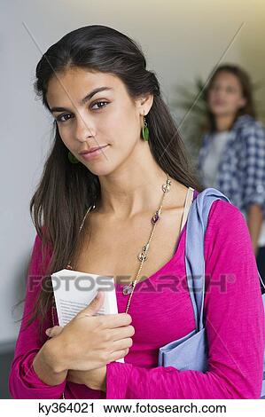 Portrait of a female university student holding a book View Large Photo Image Stock Image - Portrait of a female university student holding a book. Fotosearch