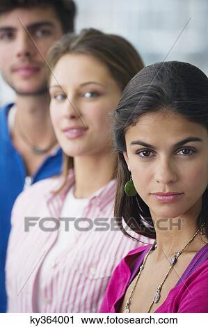 Portrait of three university students standing in a line with focus on a woman View Large Photo Image Stock Image - Portrait of three university students standing in a line with focus on a woman. Fotosearch