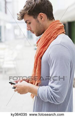Side profile of a young man using a mobile phone View Large Photo Image Stock Photography - Side profile of a young man using a mobile phone. Fotosearch