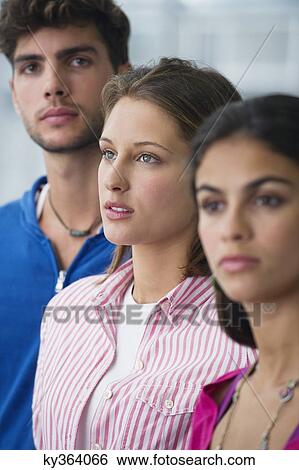 Three university students standing in a line with focus on a man View Large Photo Image Stock Photograph - Three university students standing in a line with focus on a man. Fotosearch
