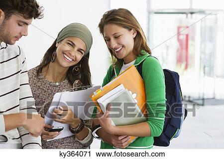 Stock Image - Three university students standing together and smiling. Fotosearch