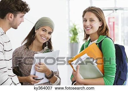 Three university students standing together and smiling View Large Photo Image Stock Photo - Three university students standing together and smiling. Fotosearch