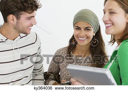 Three university students standing together and smiling View Large Photo Image Stock Photograph - Three university students standing together and smiling. Fotosearch
