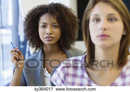 Two women sitting in classroom with focus on African American woman View Large Photo Image Stock Photo - Two women sitting in classroom with focus on African American woman. Fotosearch