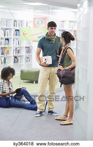 University student sitting on the floor with friends standing beside View Large Photo Image Stock Photo - University student sitting on the floor with friends standing beside. Fotosearch