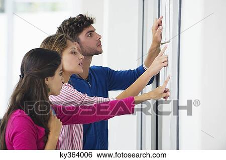 Stock Photograph - University students checking bulletin board for test result. Fotosearch