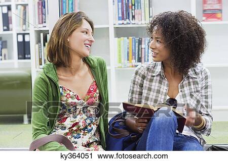University students talking while sitting on the floor in a library View Large Photo Image Stock Image - University students talking while sitting on the floor in a library. Fotosearch