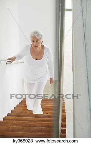High angle view of a senior woman moving up staircases View Large Photo Image Stock Image - High angle view of a senior woman moving up staircases. Fotosearch