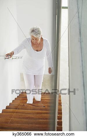 High angle view of a senior woman moving up staircases View Large Photo Image Stock Photograph - High angle view of a senior woman moving up staircases. Fotosearch