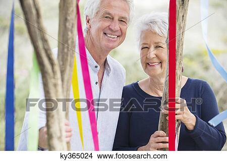 Portrait of a senior couple standing near a decorated tree View Large Photo Image Picture - Portrait of a senior couple standing near a decorated tree. Fotosearch