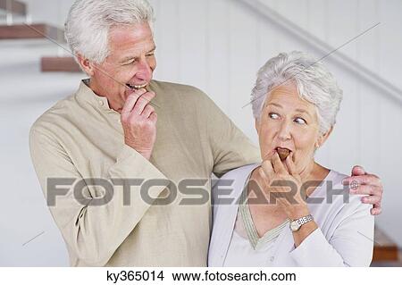 Senior couple eating chocolate at home View Large Photo Image Picture - Senior couple eating chocolate at home. Fotosearch