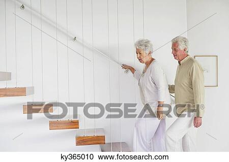 Senior couple moving up staircases View Large Photo Image Stock Image - Senior couple moving up staircases. Fotosearch