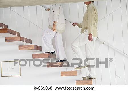 Senior couple moving up staircases View Large Photo Image Stock Photo - Senior couple moving up staircases. Fotosearch