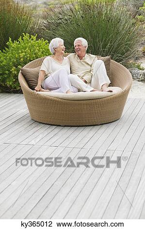 Senior couple sitting in a wicker couch View Large Photo Image Stock Image - Senior couple sitting in a wicker couch. Fotosearch